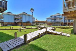 a wooden walkway in a park with some buildings at Under The Sea 405BH in Port Aransas