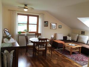 ein Wohnzimmer mit einem Sofa und einem Tisch in der Unterkunft Gästehaus Bauer am Golfplatz in Prien am Chiemsee