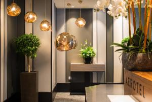 a lobby with potted plants and lights on the wall at Aerotel London Heathrow, Terminal 2 & Terminal 3 in Hillingdon