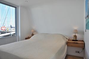 a bedroom with a bed and a large window at Hausboot Ankerplatz - Floating Home 2 in Laboe