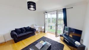 sala de estar con sofá y TV en Orange Apartments Rubislaw Mansions en Aberdeen