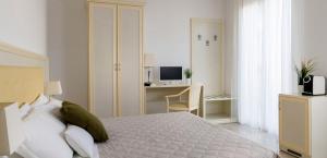 a bedroom with a bed and a desk with a television at Residence Suite Smeraldo in Riccione +16 photos