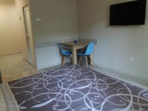 a room with a table and two chairs and a television at Студио Булаир 1 in Burgas City