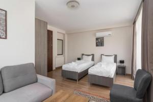 a living room with two beds and a couch at Hotel "Elesa Wera" in Tbilisi City