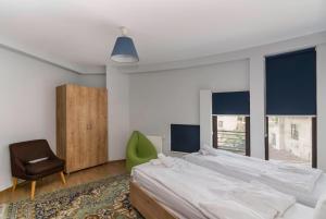 1 dormitorio con 1 cama grande y 1 silla verde en Hotel "Elesa Wera", en Tiflis