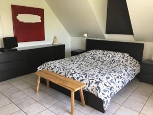 1 dormitorio con cama y banco de madera en casa matteo de haan Grote straat 152 en Vlissegem