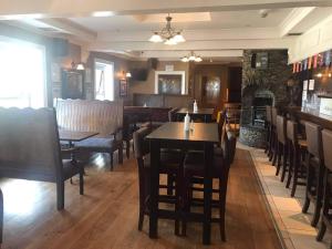 a dining room with tables and chairs and a fireplace at Caisleain Oir Hotel in Annagry
