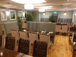 a restaurant with tables and chairs in a room at Caisleain Oir Hotel in Annagry