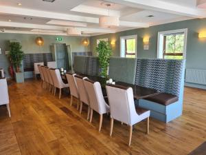 a dining room with a long table and chairs at Caisleain Oir Hotel in Annagry