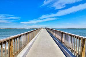 a wooden boardwalk stretches out into the ocean at Channelview 305 in Port Aransas