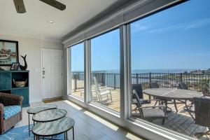 a living room with a balcony with a table and chairs at Channelview 305 in Port Aransas