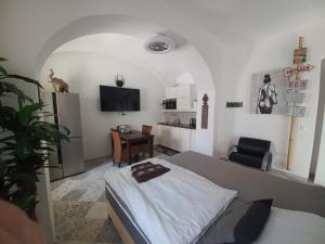 a bedroom with a bed and a desk and a tv at A-M Condominium in Veszprém