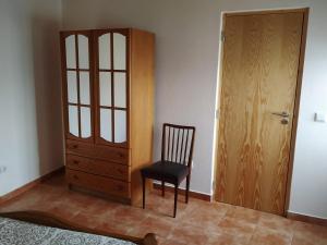 una silla sentada junto a un armario y una puerta en Casa da Eira, en Bordeiro