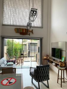 a living room with a couch and a tv at Lindo Apartamento no Mariscal, Bombinhas, com estacionamento e quintal, a 290 metros da praia do Canto Grande!!! in Bombinhas