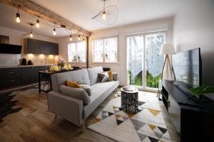 ein Wohnzimmer mit einem weißen Sofa und einer Küche in der Unterkunft #La Tardière# in Clermont-Ferrand