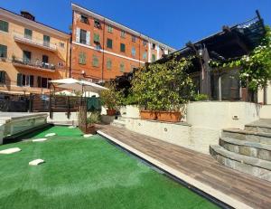 un cortile con un prato verde di fronte a un edificio di Locanda Sapori a Sanremo