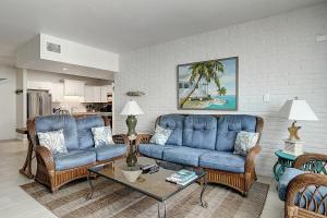 - un salon avec deux canapés bleus et une table dans l'établissement Channelview 206, à Port Aransas