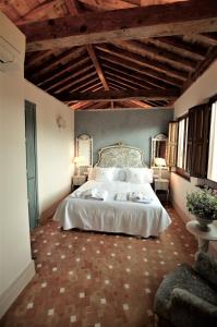 a bedroom with a large white bed with a wooden ceiling at La Corrala del Realejo in Granada