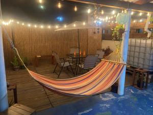 a hammock on a patio with a table and chairs at Blue Paradise Curaçao in Willemstad