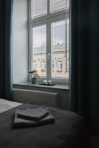 a bed with a towel on it in front of a window at Delis Apartments - Dluga Street 11/3 in Krakow