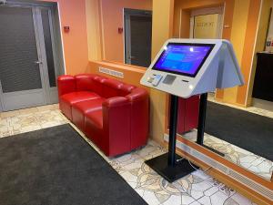 a waiting room with a red chair and a monitor at Dorell in Tallinn +51 photos