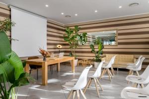 a restaurant with a wooden table and white chairs at Hotel Admiral Lugano in Lugano