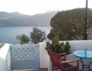 een patio met een tafel, een tafel en een hek bij ASVESTOTI MESONETTES BLUE LIGHT ΣΙΕΛ ΜΕΖΟΝΕΤΕs in Pera Gyalos