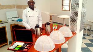 a man standing next to a table in a kitchen at Watamu Solana Apartments in Watamu