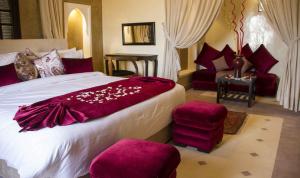 a bedroom with a large bed with purple pillows at Kasbah ATFEL in Ourika