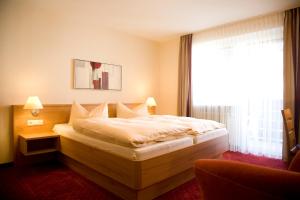 a bedroom with a large bed with a window at Gasthaus Merkel Hotel in Bad Berneck im Fichtelgebirge