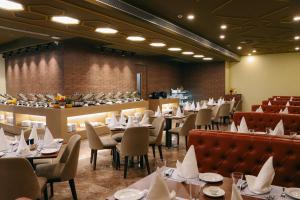 a dining room with tables and chairs and a bar at Playotel Premier Guna in Guna