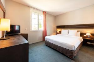 a hotel room with a bed and a television at Résidence de Diane - Toulouse in Toulouse