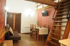 a dining room with a table and chairs and a television at EL VASALLO in Tragacete