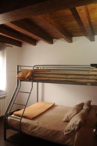 metalowe łóżko piętrowe w pokoju z sufitem w obiekcie EL VASALLO w mieście Tragacete