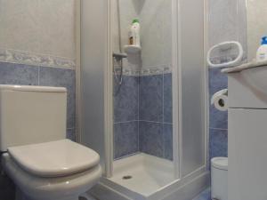 Un baño con inodoro blanco y ducha. en CASA PASAXE-Bajo, en A Guarda