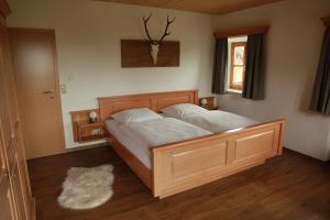 a bedroom with a large bed with white sheets at Ferienwohnung Fritzenwenger in Übersee