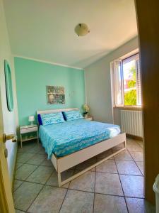 una camera da letto con un letto con lenzuola blu e una finestra di Brezza di Mare a Torre Canne