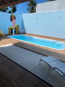 a swimming pool with a table and a bench next to it at Casa Frida Aracaju a 500m da praia in Aracaju