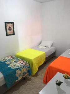 a room with two beds with colorful sheets at Casa Frida Aracaju a 500m da praia in Aracaju