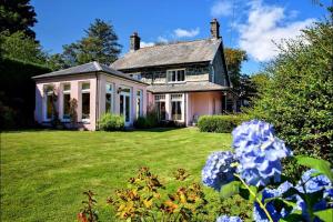 an old house with a yard with flowers at Eisteddfa in Criccieth