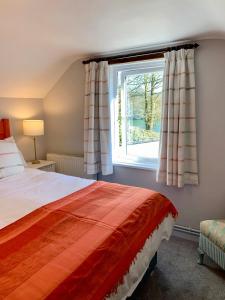 a bedroom with a bed and a window at Tresowes Green Cottage in Helston +25 photos