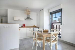 uma cozinha com uma mesa de madeira e cadeiras em Bel appartement pour 6 personnes avec balcon en bord de mer em Pléneuf-Val-André