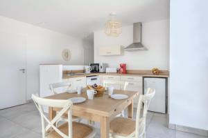 uma cozinha com uma mesa de madeira e cadeiras em Bel appartement pour 6 personnes avec balcon en bord de mer em Pléneuf-Val-André