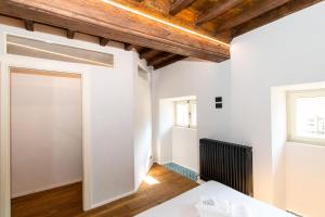 Drzwi otwarte w pokoju z białymi ścianami i drewnianymi sufitami w obiekcie Stylish Quardilatero Romano Central Flat w Turynie