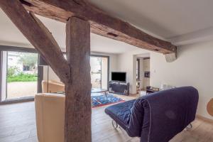 sala de estar con sofá azul y TV en Maison de charme pour 6 personnes à Jard-Sur-Mer, en Jard-sur-Mer
