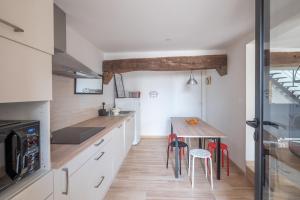 cocina con armarios blancos y mesa de madera en Maison de charme pour 6 personnes à Jard-Sur-Mer, en Jard-sur-Mer