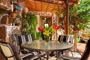 Una mesa con un jarrón de flores en un patio. en Casa Los Pinos, en Agüimes