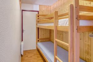 um quarto com 2 beliches e uma porta em Appartement moderne et lumineux a Adervielle em Val Louron