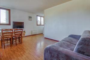 uma sala de estar com um sofá e uma mesa em Appartement moderne et lumineux a Adervielle em Val Louron