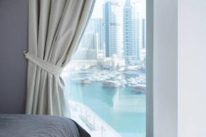a bedroom with a window with a view of a harbor at WSuites - Big Terrace with Beautiful Marina View in Dubai